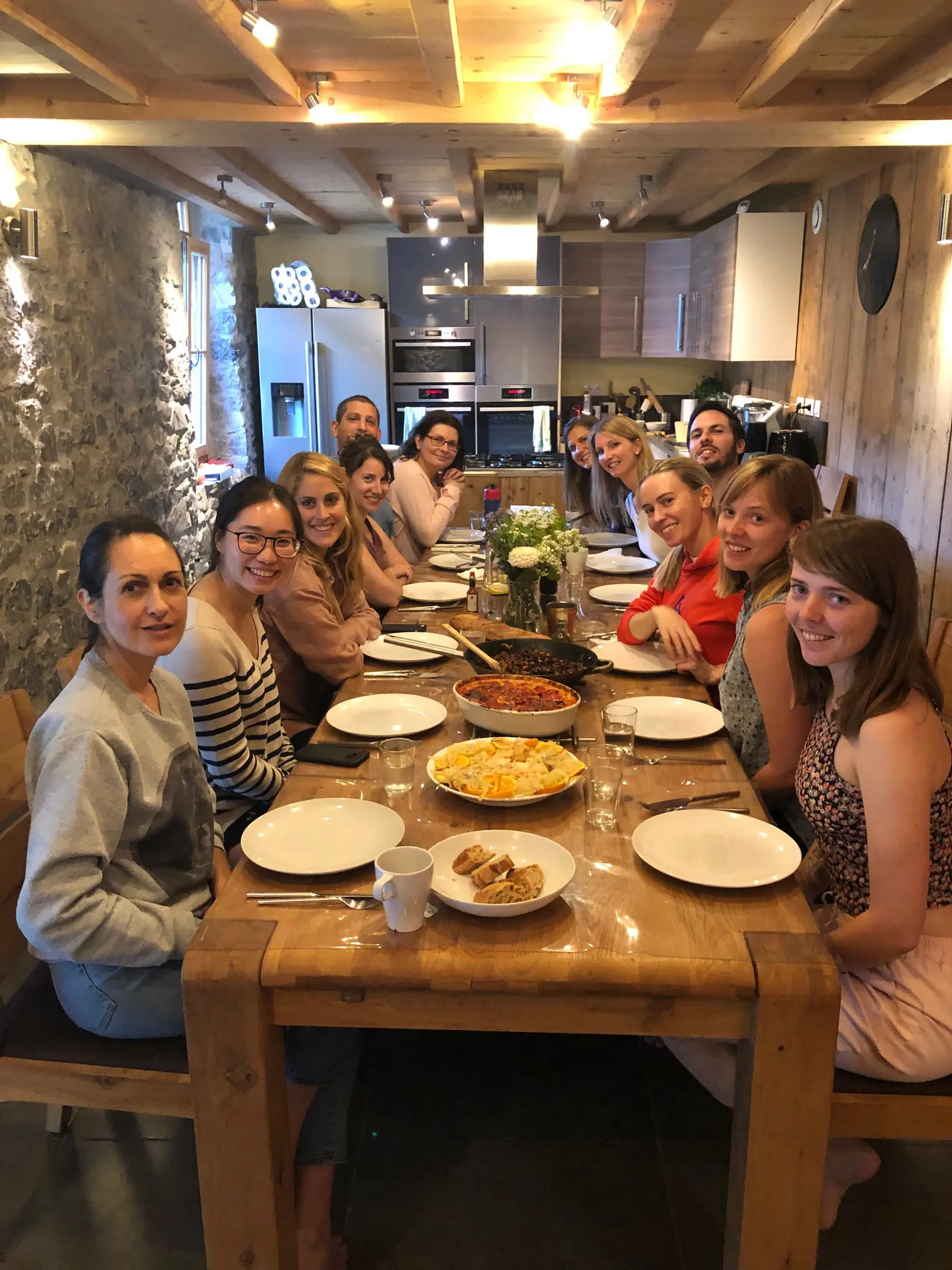 Guests sharing a meal around the long table at L’Ecuela